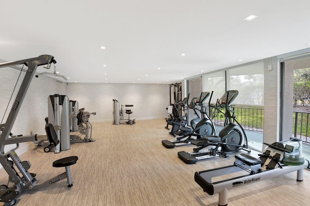 workout area featuring carpet, a wall of windows, recessed lighting, and baseboards