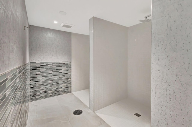 full bath featuring a walk in shower and tile walls