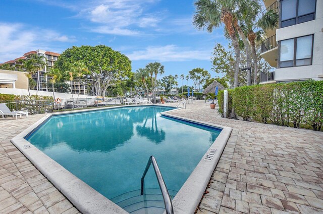 community pool with fence and a patio