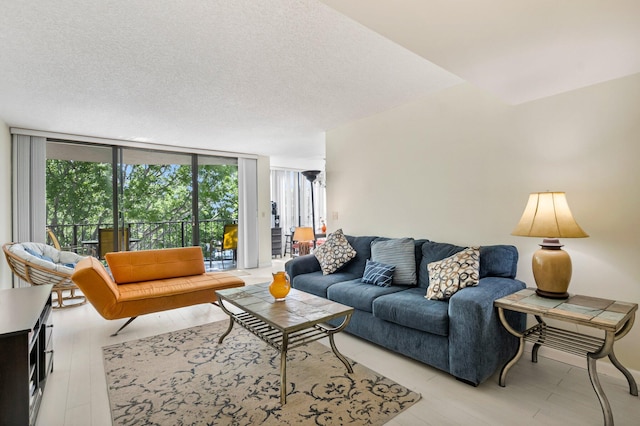 living area featuring healthy amount of natural light, expansive windows, a textured ceiling, and light wood finished floors
