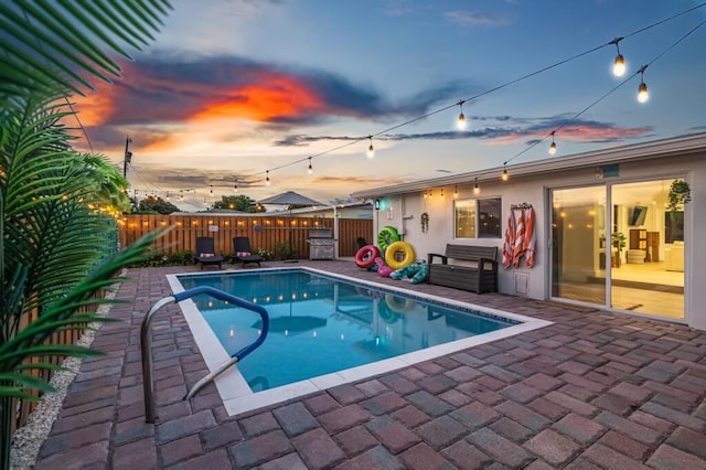 1445 Cindy Dr, Lake Worth Beach, FL 33461 - pool at dusk featuring a fenced backyard and a patio area
