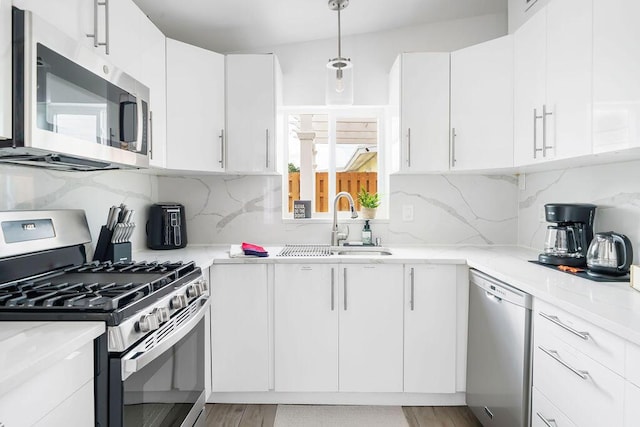 1445 Cindy Dr, Lake Worth Beach, FL 33461 - kitchen featuring appliances with stainless steel finishes, tasteful backsplash, and white cabinetry