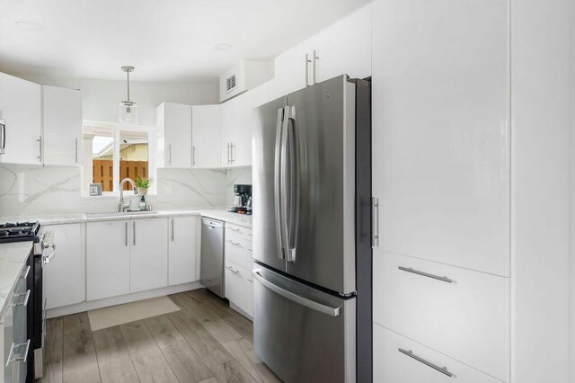 1445 Cindy Dr, Lake Worth Beach, FL 33461 - kitchen with appliances with stainless steel finishes, backsplash, a sink, and white cabinetry