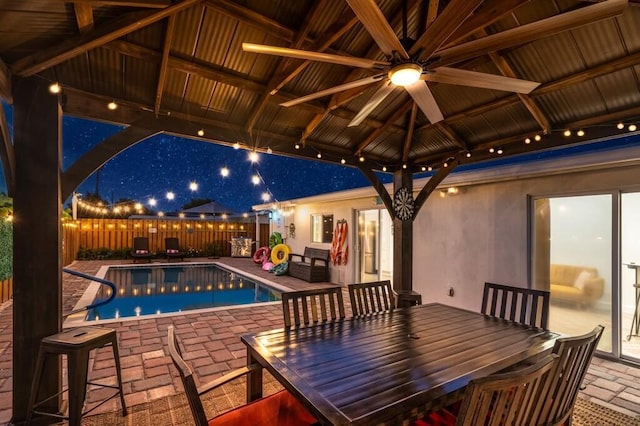 1445 Cindy Dr, Lake Worth Beach, FL 33461 - pool at night featuring a patio area, a ceiling fan, a fenced backyard, and outdoor dining area