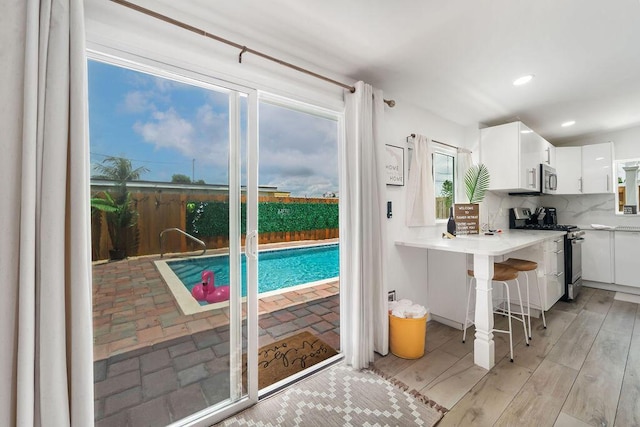 1445 Cindy Dr, Lake Worth Beach, FL 33461 - kitchen with appliances with stainless steel finishes, backsplash, white cabinetry, light countertops, and recessed lighting