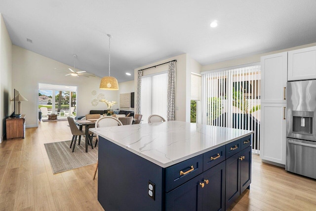 12811 Oak Knoll Dr, Palm Beach Gardens, FL 33418 - kitchen featuring stainless steel fridge with ice dispenser, open floor plan, blue cabinets, ceiling fan, and vaulted ceiling