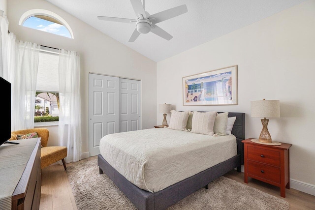 12811 Oak Knoll Dr, Palm Beach Gardens, FL 33418 - bedroom with light wood-style floors, a closet, baseboards, a ceiling fan, and high vaulted ceiling