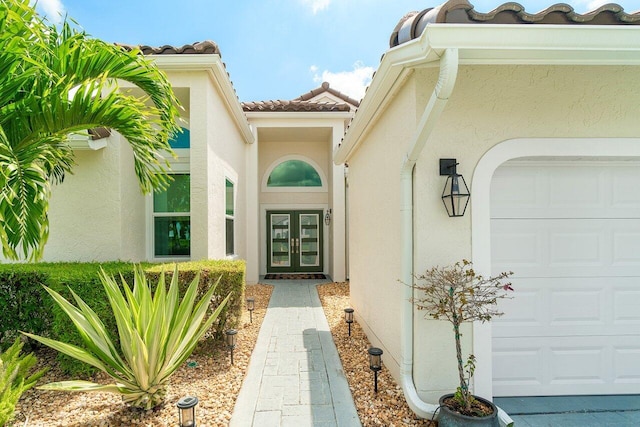 12811 Oak Knoll Dr, Palm Beach Gardens, FL 33418 - property entrance featuring french doors, stucco siding, and a garage