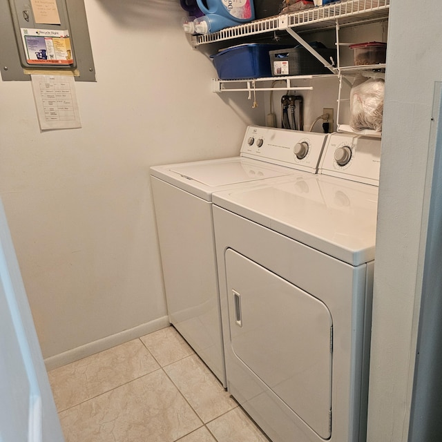 washroom featuring separate washer and dryer, baseboards, and light tile patterned flooring