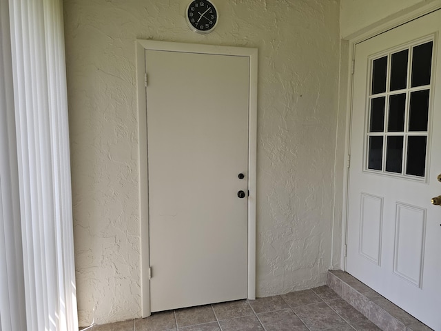 doorway to property featuring stucco siding