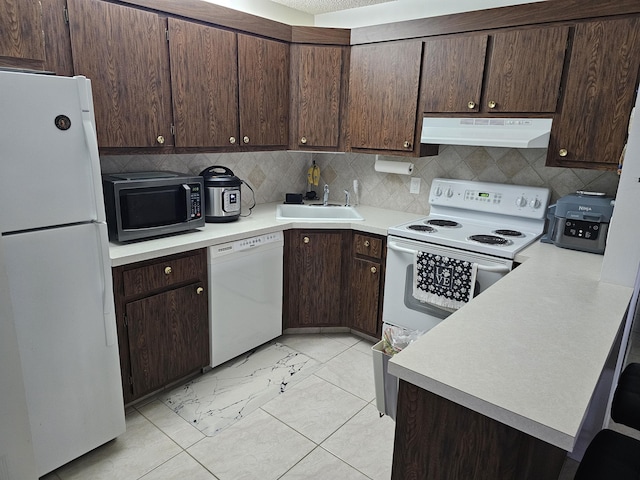 kitchen featuring white appliances, exhaust hood, a sink, and dark brown cabinets