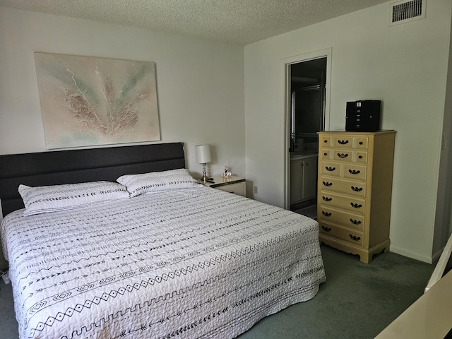 bedroom featuring carpet flooring, a textured ceiling, and ensuite bathroom