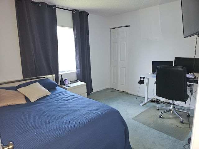 bedroom featuring carpet flooring, a desk, baseboards, and a textured ceiling