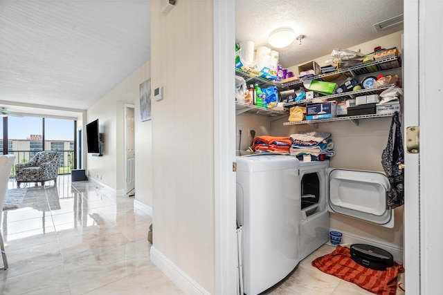 7290 Kinghurst Dr Unit 607, Delray Beach, FL 33446 - washroom with washer and clothes dryer and a textured ceiling