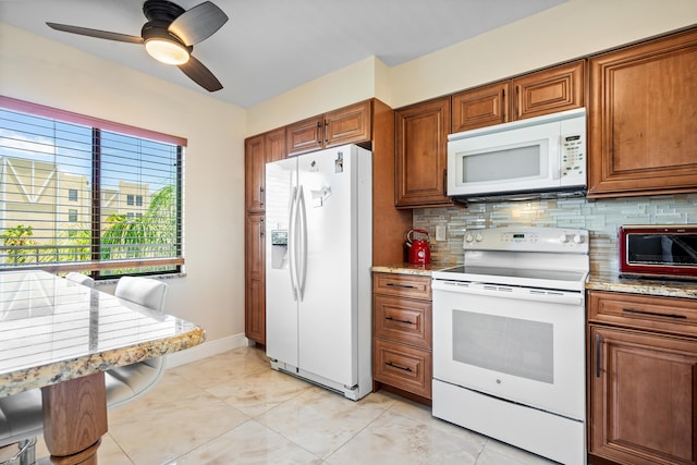 7290 Kinghurst Dr Unit 607, Delray Beach, FL 33446 - kitchen with white appliances, brown cabinetry, decorative backsplash, a ceiling fan, and light stone counters