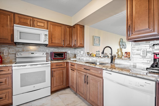 7290 Kinghurst Dr Unit 607, Delray Beach, FL 33446 - kitchen featuring white appliances, brown cabinetry, backsplash, and light stone counters