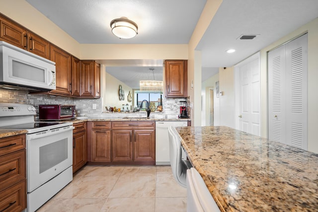 7290 Kinghurst Dr Unit 607, Delray Beach, FL 33446 - kitchen with white appliances, tasteful backsplash, brown cabinetry, light stone countertops, and recessed lighting