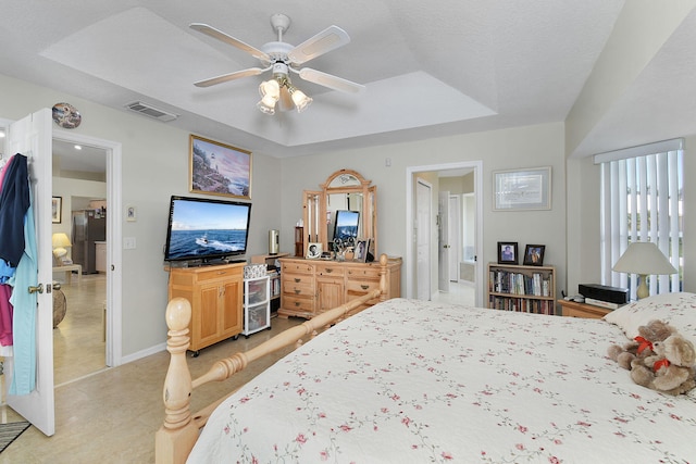 3204 SE Otis Ln, Port Saint Lucie, FL 34984 - bedroom with a raised ceiling, baseboards, ceiling fan, freestanding refrigerator, and ensuite bath