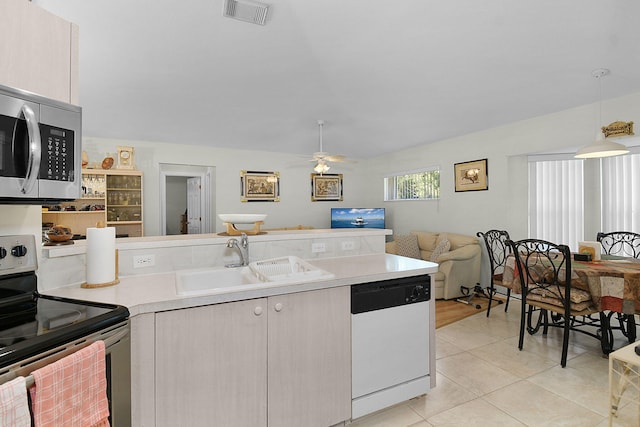 3204 SE Otis Ln, Port Saint Lucie, FL 34984 - kitchen with stainless steel appliances, a sink, open floor plan, light countertops, and light tile patterned flooring