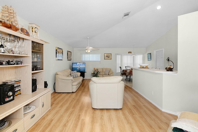 3204 SE Otis Ln, Port Saint Lucie, FL 34984 - living room with light wood-style floors, a ceiling fan, vaulted ceiling, baseboards, and recessed lighting