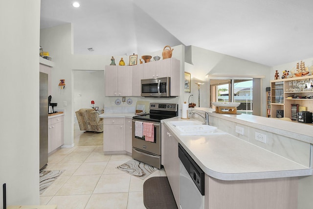 3204 SE Otis Ln, Port Saint Lucie, FL 34984 - kitchen featuring appliances with stainless steel finishes, lofted ceiling, a peninsula, light countertops, and light tile patterned flooring