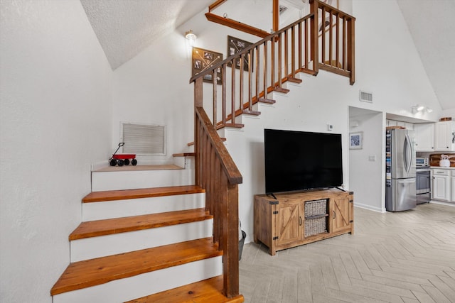 12389 186th St N, Jupiter, FL 33478 - staircase featuring lofted ceiling, baseboards, and a textured ceiling