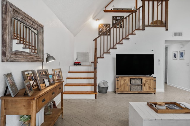 12389 186th St N, Jupiter, FL 33478 - living area featuring stairway, baseboards, high vaulted ceiling, and a textured ceiling