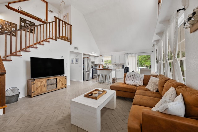 12389 186th St N, Jupiter, FL 33478 - living area featuring high vaulted ceiling, stairs, and baseboards