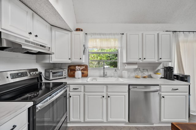 12389 186th St N, Jupiter, FL 33478 - kitchen featuring stainless steel appliances, under cabinet range hood, a sink, white cabinetry, and light countertops