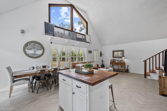 12389 186th St N, Jupiter, FL 33478 - kitchen featuring high vaulted ceiling, wooden counters, white cabinetry, baseboards, and open floor plan
