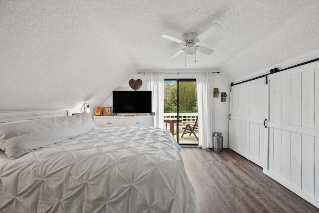 12389 186th St N, Jupiter, FL 33478 - bedroom with a textured ceiling, a barn door, vaulted ceiling, access to exterior, and wood finished floors