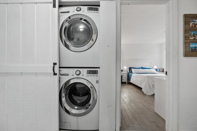 12389 186th St N, Jupiter, FL 33478 - clothes washing area with stacked washer and clothes dryer and wood finished floors