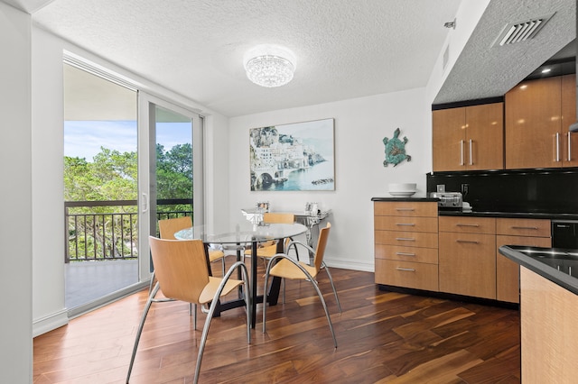 901 E Camino Real Unit 5C, Boca Raton, FL 33432 - dining room with dark wood-style flooring, baseboards, a textured ceiling, and a chandelier