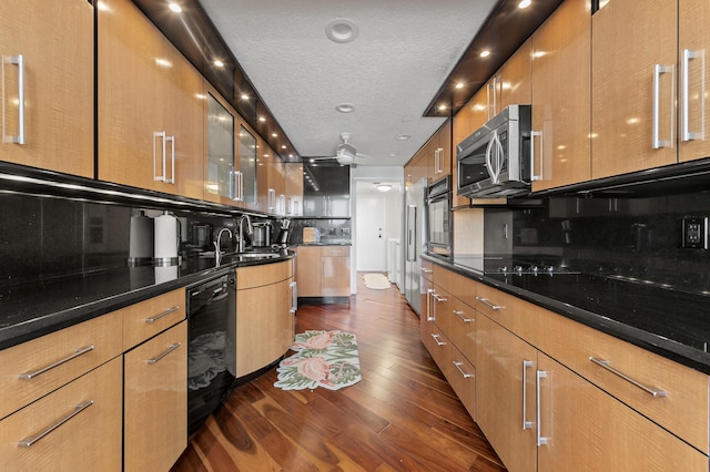 901 E Camino Real Unit 5C, Boca Raton, FL 33432 - kitchen featuring black appliances, a sink, dark wood-style floors, glass insert cabinets, and modern cabinets