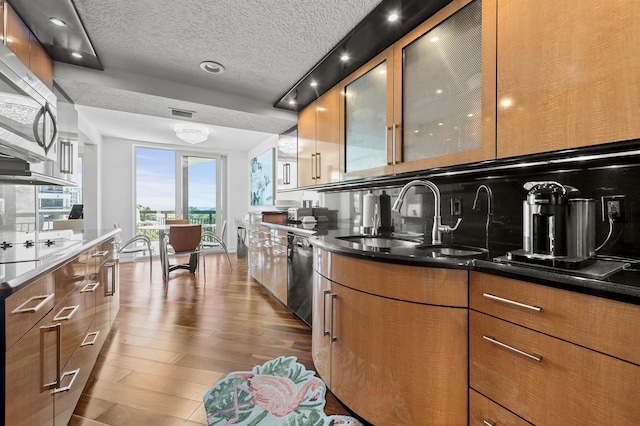 901 E Camino Real Unit 5C, Boca Raton, FL 33432 - kitchen featuring a sink, appliances with stainless steel finishes, a textured ceiling, brown cabinetry, and dark wood-type flooring