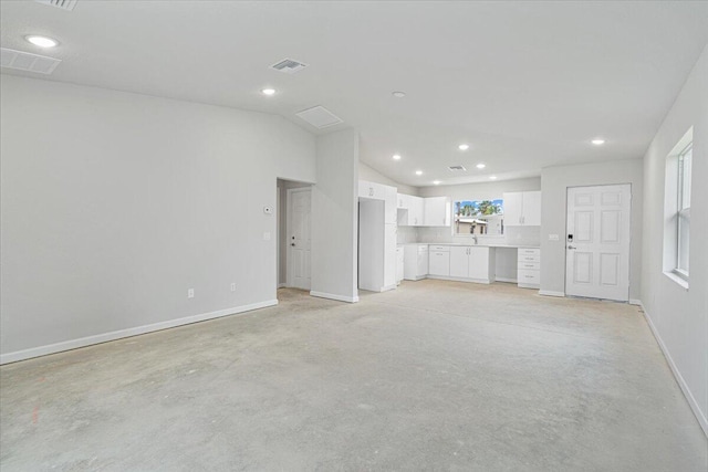 unfurnished living room featuring baseboards, lofted ceiling, and recessed lighting