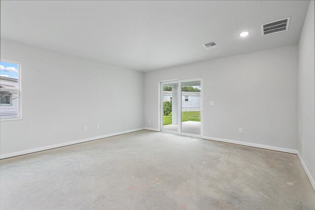 unfurnished room with concrete floors, baseboards, and recessed lighting