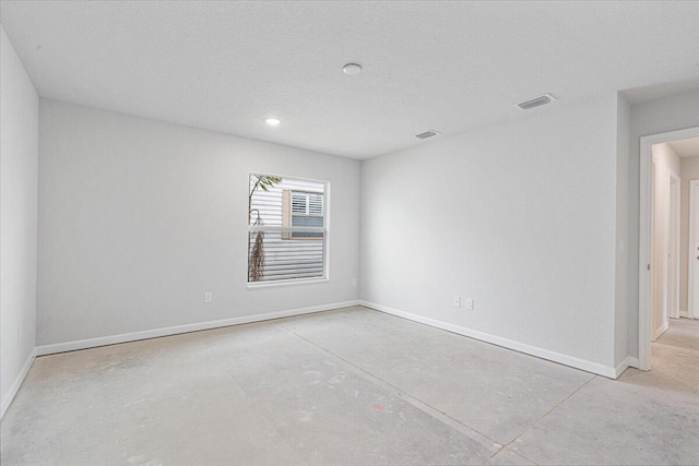 spare room featuring concrete floors, baseboards, recessed lighting, and a textured ceiling