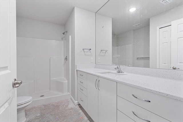 full bath featuring a stall shower, toilet, and vanity