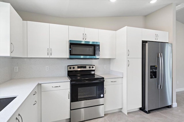 15 Jacaranda Ln, Port Saint Lucie, FL 34952 - kitchen featuring appliances with stainless steel finishes, vaulted ceiling, tasteful backsplash, and white cabinets