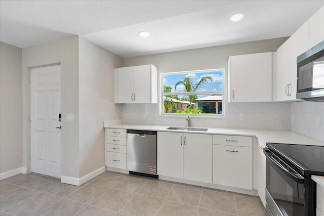 15 Jacaranda Ln, Port Saint Lucie, FL 34952 - kitchen featuring stainless steel appliances, a sink, light countertops, white cabinetry, and backsplash