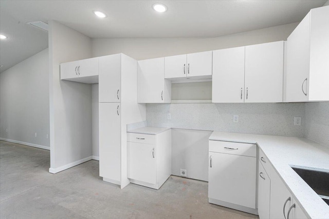 kitchen featuring concrete flooring, decorative backsplash, vaulted ceiling, recessed lighting, and white cabinets