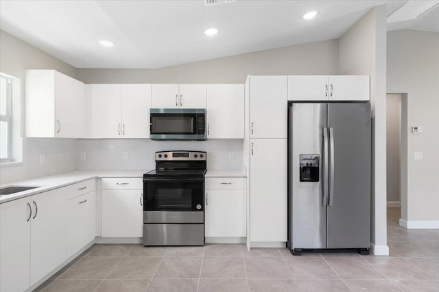 15 Jacaranda Ln, Port Saint Lucie, FL 34952 - kitchen featuring stainless steel appliances, light countertops, backsplash, white cabinetry, and lofted ceiling
