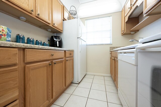 915 Savannas Point Dr Unit E, Fort Pierce, FL 34950 - kitchen featuring white appliances, light countertops, light tile patterned floors, and baseboards