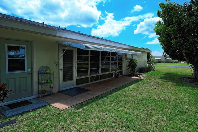 915 Savannas Point Dr Unit E, Fort Pierce, FL 34950 - rear view of house featuring stucco siding and a lawn
