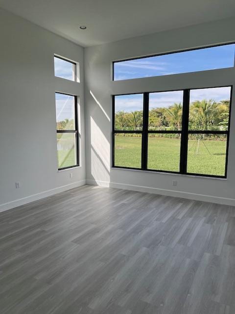 unfurnished room featuring dark wood-type flooring, baseboards, and recessed lighting