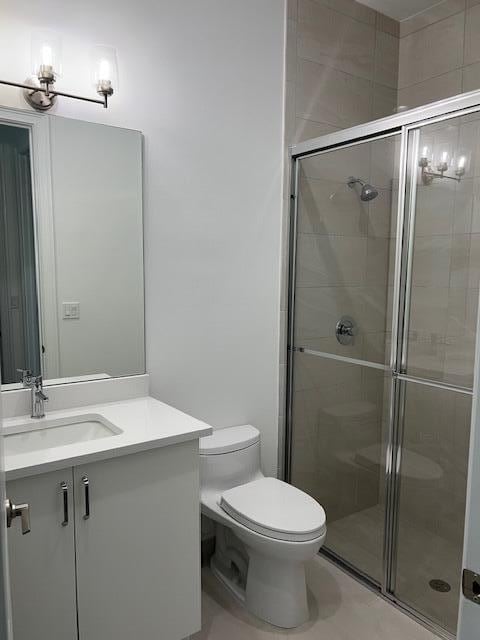 bathroom featuring a shower stall, toilet, and vanity