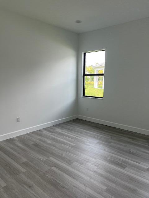 empty room featuring baseboards and dark wood-style floors