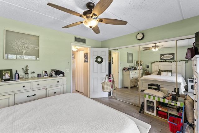 bedroom featuring wood finished floors, ceiling fan, and a closet