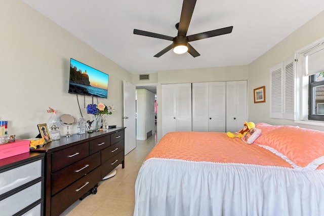 bedroom with light tile patterned floors, a closet, and a ceiling fan